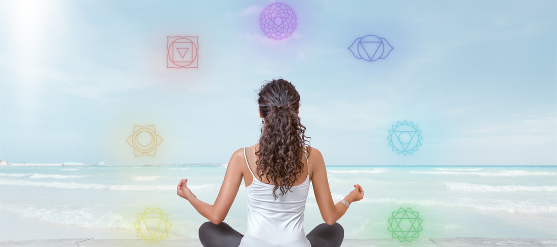 Woman meditating with the chakra symbols