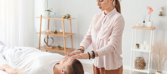 Woman doing energy healing on a man with a hand position above his head