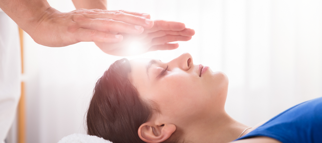 A woman gets Reiki Healing through an over head position of hands